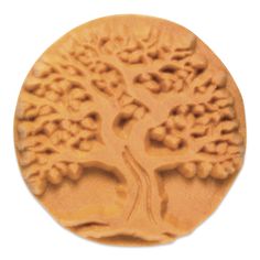 a tree carved into the side of a round cookie molding sheet on a white background