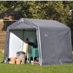 a large gray tent sitting on top of a lush green field