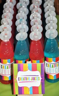 colorful juices are lined up on a table with tags in front of them that say creative juices