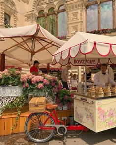 an outdoor food cart with flowers on display