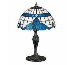 a table lamp with a blue and white glass shade on the top, sitting in front of a white background