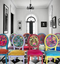 the chairs are all different colors and have floral designs on them, as well as black and white checkered flooring