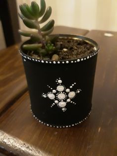 a small potted plant sitting on top of a wooden table