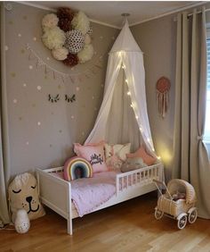 a child's bedroom decorated in pink, white and gold with a canopy bed