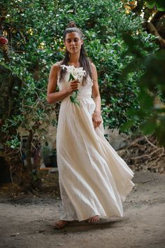 a woman in a white dress holding flowers