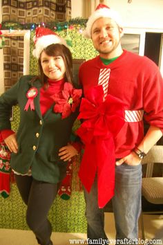 a man and woman standing next to each other in front of christmas decorations on the wall