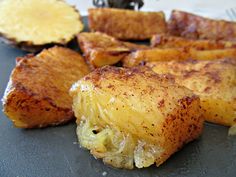 some food that is on a black plate and has pineapple slices cut up next to it