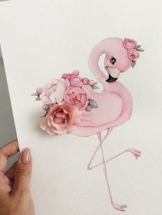 a pink flamingo with flowers on it's head is standing next to a piece of paper