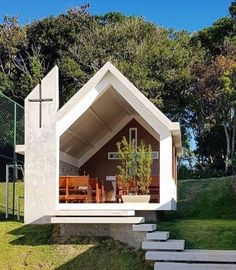 a small white house sitting on top of a lush green field