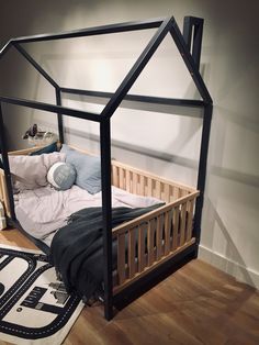 a bed with a wooden frame and mattress in a room that has hardwood flooring