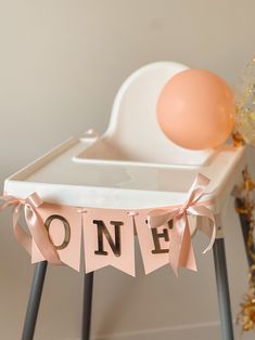 a baby's first birthday party with pink and gold decorations, balloons and streamers