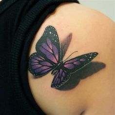 a woman's shoulder with a purple butterfly tattoo on it