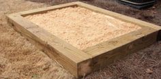 a wooden box sitting on top of dry grass