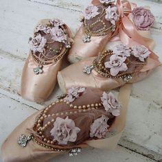 three pairs of ballet shoes with flowers on them