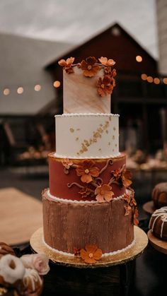 a three tiered cake sitting on top of a table next to other desserts