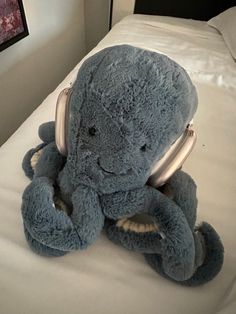 an elephant stuffed animal sitting on top of a bed with headphones in it's ears