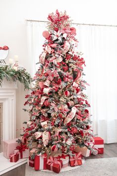 a christmas tree decorated with red and silver ribbons, bowes and other holiday decorations