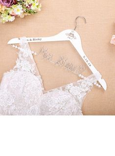 a wedding dress hanger with the word mr and mrs on it next to flowers