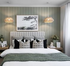 a bedroom with green walls and white bedding, two lamps above the headboard