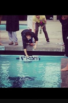 a person jumping into a swimming pool with their feet in the water while others look on