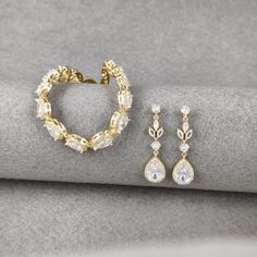 Presenting the chic Bohemian Gold Bridal Jewelry Set, a stunning combination of a teardrop crystal bracelet with its coordinating floral gold earrings, perfect for the bride's special day. The bracelet, sparkling with cubic zirconia teardrops, adds a touch of glamour to any attire, ideal for weddings, formal events, and other celebrations. It's a symbol of grace, designed to be a cherished keepsake. The Gold Crystal Bridal Earrings, with their exquisite pavé-set teardrop crystals, complement the Elegant Gold Drop Jewelry Set, Gold Cubic Zirconia Wedding Bracelets, Gold Teardrop Jewelry For Wedding, Silver Teardrop Bracelet For Wedding, Gold Plated Drop Jewelry For Wedding, Gold Cubic Zirconia Bridal Earrings For Bridesmaids, Wedding Gold Plated Drop Jewelry, Gold Pear-shaped Bridal Earrings For Wedding, Pear-shaped Silver Bracelet For Weddings