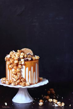 a cake with caramel drizzled on top and popcorn in the middle