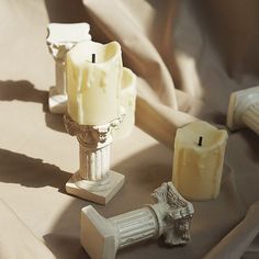 three candles sitting on top of a table next to some other items in front of them