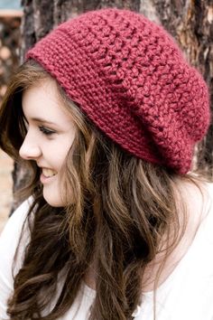 a woman with long hair wearing a red knitted hat