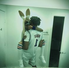 a man taking a selfie in front of a mirror with a bunny costume on