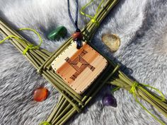 a small wooden cross is on top of some bamboo sticks and beads, along with other items