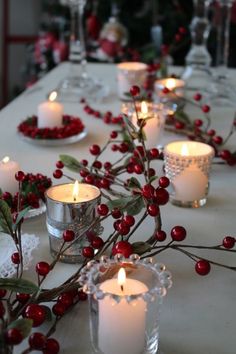 the table is set with candles and berries