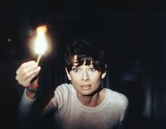 a man holding a lit candle in his hand