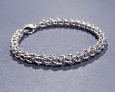 This beautiful 925 sterling silver bracelet is handcrafted into a fine Jens Pind weave pattern using high quality sterling silver jump rings and lobster clasp as closure. This woven chainmail bracelet measures 7.5" (~19.05 cm) in length, 6mm width, and weighs 0.65 oz (18.41g).     This is a one-of-a-kind jewelry piece, the one you see in the photos is the one you will receive. Feel free to contact me if you have any questions. :) Thanks for visiting my shop! ❤ Follow me on social: @chakramoonarts Website: www.chakramoon.com Unisex 925 Sterling Silver Bracelet Jens Pind Weave Chainmaille handmade JP3 chainmail jewelry chain mail bracelet silver wire jewelry Chainmail Jewelry Bracelets, Luxury Silver Chainmail Jewelry, Chainmail Weaves, Chainmaille Ring, Chainmaille Jewelry Patterns, Chainmail Patterns, Silver Wire Jewelry, Jump Ring Jewelry, Chainmaille Jewelry