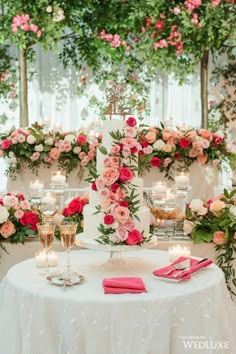 a wedding cake with pink flowers and candles