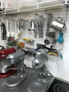 a kitchen area with various appliances and utensils hanging on the pegboard wall