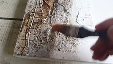 a person is using a brush to paint a piece of art