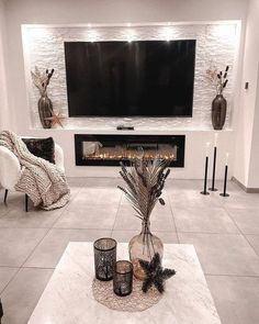 a living room with white walls and a large television mounted on the wall above it