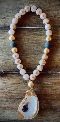 a beaded bracelet with an agate shell and stone pendant on top of it