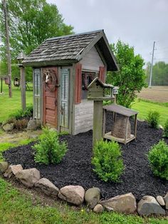 a small shed with a bird feeder in the front and an outhouse behind it