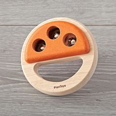 an orange wooden toy with holes in it