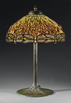 a lamp that is sitting on top of a table with a dragonfly design on it