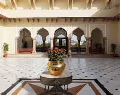 a potted plant sitting on top of a table in a room with arches and doorways