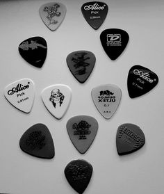 a bunch of guitar picks are arranged in a circle on a white surface with black and white lettering