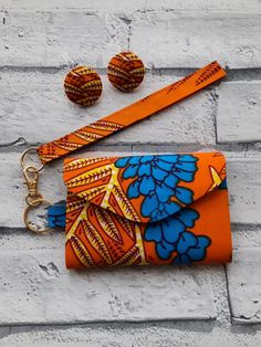 an orange and blue flowered purse with matching wristlet, earrings and keychain