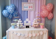 a table topped with lots of desserts and balloons