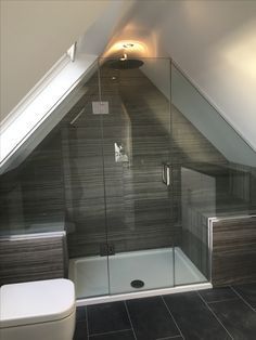 a bathroom with a toilet, sink and shower in it's attic style home