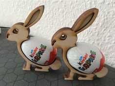 two wooden toy rabbits holding an easter egg