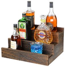 an assortment of liquor bottles and glasses in a wooden holder