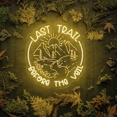 the last trail before the void neon sign surrounded by evergreens and pine cones, on a dark background