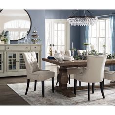 a dining room with blue walls and white chairs